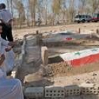 Un grupo de iraquíes rezan ante las tumbas de los hijos de Sadam