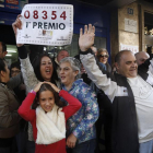 Agraciados con el primer premio del sorteo de El Niño, dotado con 2.000.000 de euros a la serie, lo celebran con el número en la mano, en las puertas de la administración número 3 de Torrent.