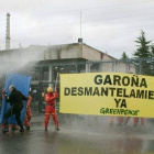 Miembros de Greenpeace, esta mañana, entre los manguerazos empleados para evitar que se acercaran a la central de Garoña.