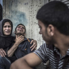 Varios palestinos lloran la muerte de sus familiares en el bombardeo a un colegio de la ONU.