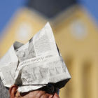 Un hombre se protege del sol con un gorro hecho de papel.