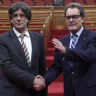 El nuevo presidente de la Generalitat Carles Puigdemont junto a Artur Mas.
