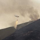 Un helicóptero descarga agua en uno de los valles afectado por el incendio, cerca de Tejeira.