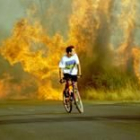 En la foto, un ciclista escapa de las llamas en su bicicleta por la carretera de Villaquilmabre