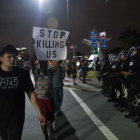 Manifestantes pasean con pancartas ante el cordón policial, esta madrugada en Charlotte.
