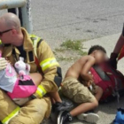Dos bomberos consuelan a dos niños, en Texas.