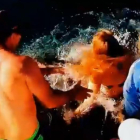 Melissa Brunning, en el momento en que estuvo a punto de ser arrastrada al agua por el tiburón al que intentaba alimentar.