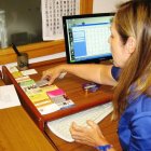 La responsable de la oficina con las tarjetas laborales de varios de los proyectos.