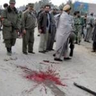 Oficiales de seguridad afganos inspeccionan el lugar de uno de los ataques suicidas en Kandahar