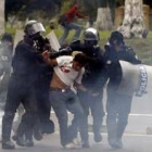 Un manifestante es arrestado por varios policías en Quito