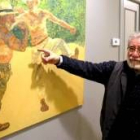 El pintor Manuel Alcorlo señala un cuadro en el que figura un cómico retrato de sí mismo