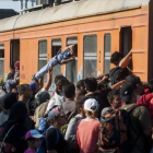 Decenas de inmigrantes y refugiados intentan subir a un tren en una estación de Macedonia con destino a Serbia, el martes.
