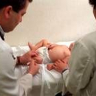 Imagen de dos pediatras vacunando a un bebé