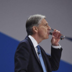 El ministro británico de Economía, Philip Hammond, bebe agua durante su discurso en el congreso anual del Partido Conservador en Birmingham.