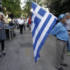 Un simpatizante del partido conservador de Nueva Democracia sale a la calle vestido de azul y con la bandera griega, a 20 días de las elecciones generales.