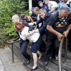 Los policías sacan en volandas a la primera ministra de Australia, tras ser abucheada por aborígenes, el jueves, en Canberra.
