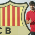 André Gomes posa junto al escudo del Barcelona después de su presentación como nuevo jugador azulgrana. ANDREU DALMAU