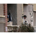Un policía mira por una de las ventanas del piso donde se atrincheró Mohamed Merah, el jueves en Toulouse, tras el asalto.