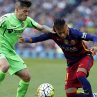 El delantero brasileño del FC Barcelona Neymar da Silva (d) pelea un balón con el defensa del Getafe Emiliano Buendía.