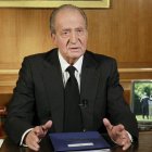 El rey, durante su mensaje de pésame, con la última fotografía que se hizo con Suárez, ambos de espaldas.