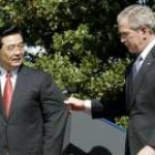 El presidente Hu Jintao observa cómo Bush le tira de la manga de su chaqueta en la Casa Blanca