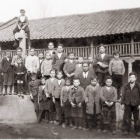Niños posando con el maestro en la plaza del pueblo de Sueros de Cepeda. Una escena del trabajo en las eras.