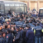 Agentes de los carabinieri acompañan a los detenidos para su traslado en autobuses