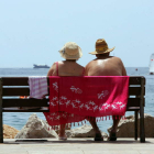 Una pareja contempla el mar en una plaza del Levante español.