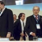 José María Aznar pasa entre Mariano Rajoy y Manuel Fraga tras llegar tarde al congreso del partido
