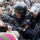 Agentes antidisturbios intentan apresar a un activista rodeados de manifestantes, este lunes en Moscú.