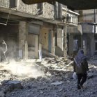 Un hombre camina entre los escombros de un edificio.