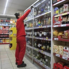 Una empleada repone los productos en un supermercado.