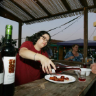 Un hombre degusta chorizo al vino en una de las casetas.