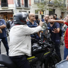 Discusión entre un grupo de personas que cortan una calle en Barcelona y unos motoristas que quieren seguir circulando.