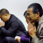 Familiares de los pasajeros del vuelo de Malaysia Airlines rezan, en un hotel de Pekín.