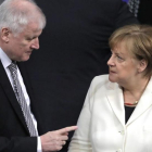 Seehofer (izq) habla con Merkel en el Parlamento alemán, en Berlín, el 14 de marzo.
