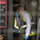 La policía científica busca pruebas en el bar donde fue asesinado su propietario.