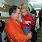 Gustavo Aranzana, empapado, sostiene en brazos a su hija en el vestuario
