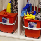 Cubos y productos de limpieza en un armario