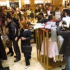 Varias personas realizando sus compras en unos grandes almacenes