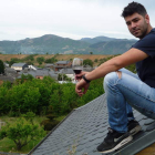 César Márquez, sobre un tejado en el Castro de la Ventosa, con Valtuille de Abajo y los viñedos del Bierzo al fondo. B. FERNÁNDEZ