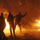 Manifestantes lanzan cócteles molotov durante los enfrentamientos con los antidisturbios, anoche en el centro de Kiev.