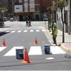 En la imagen, un operario pintando uno de los pasos de peatones de la calle La Martina.