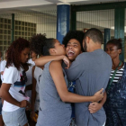 Bianca Alves (centro) es consolada tras conocer la muerte de su hermana, de 13 años, en Río de Janeiro, Brasil.