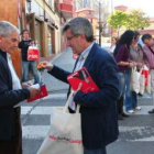El candidato del PSOE regala una flor a un vecino.