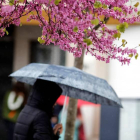 Una mujer se resguarda de la lluvia bajo su paraguas