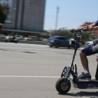 Un hombre circula por Barcelona en un patinete eléctrico de grandes dimensiones.