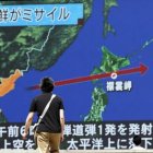 Un viandante observa la trayectoria del misil norcoreano en una pantalla gigante colocada en Tokio (Japón).
