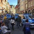 Vecinos y turistas circulan por el centro de Münster, entre furgonetas de la policía, tras el atropello de ayer.