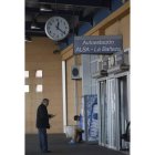 Dos viajeros esperan en la estación a mediodía de ayer.